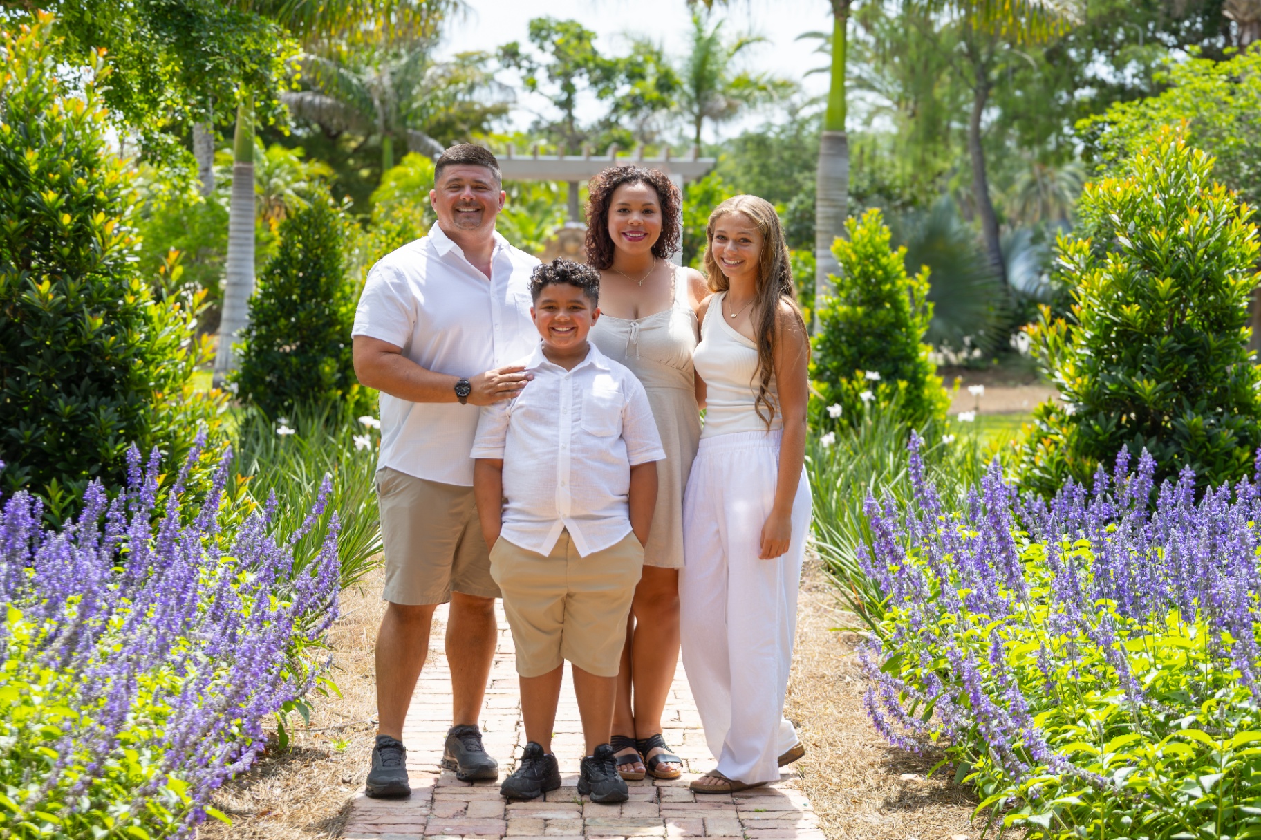 A family standing together in a sunlit garden
